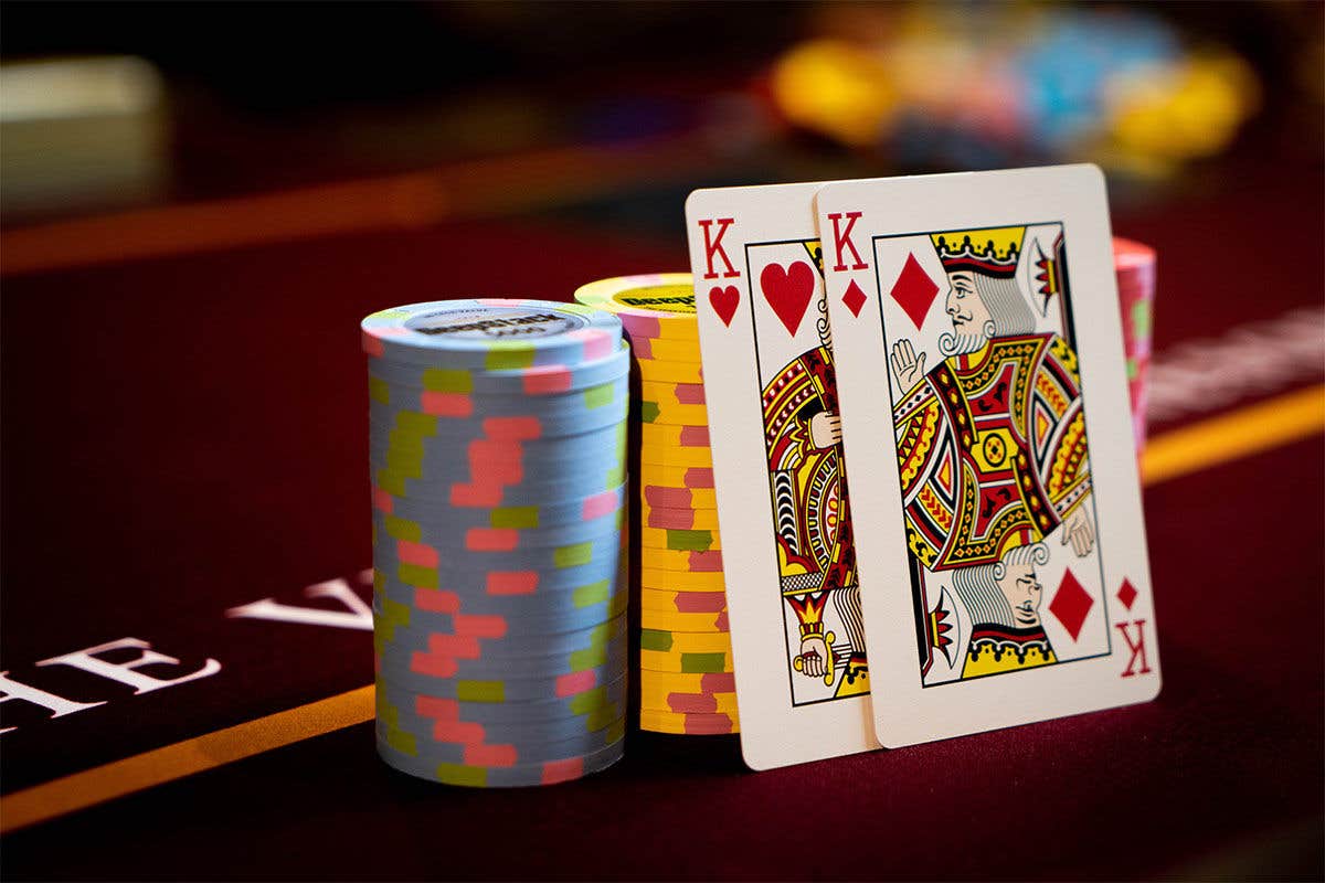 Two queen cards resting on a stack of poker chips.