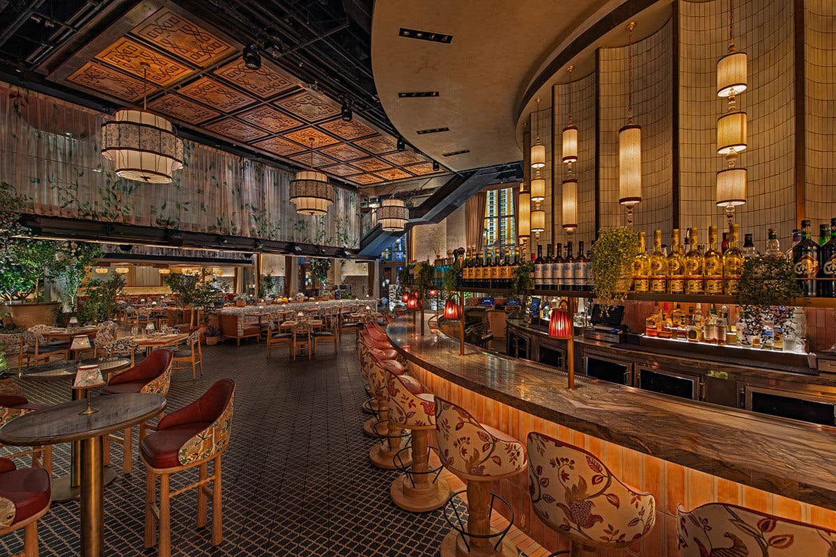 The interior at LAVO Italian Restaurant Las Vegas with a bar, dining tables and chairs.