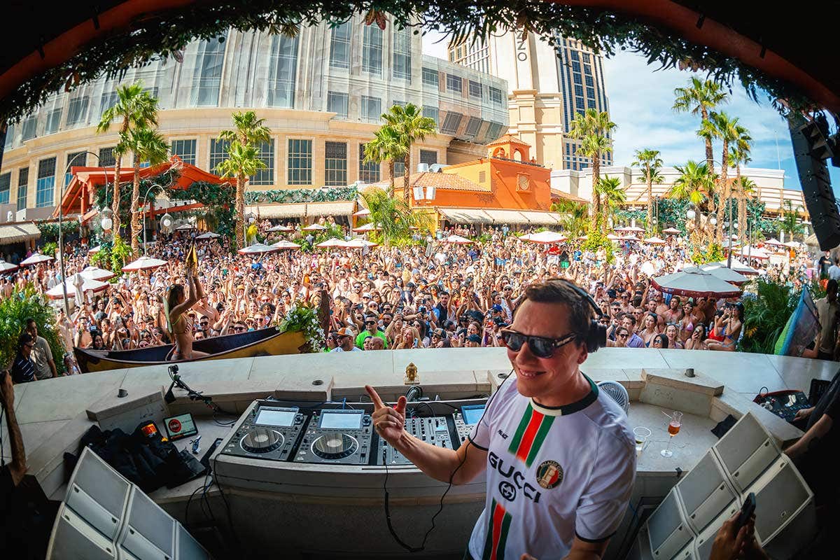 Tiësto in the DJ booth at TAO Beach in front of a large crowd