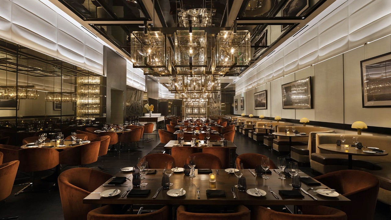 Elegant, modern restaurant with plush seating, chandeliers, and a sophisticated ambiance, set for fine dining.