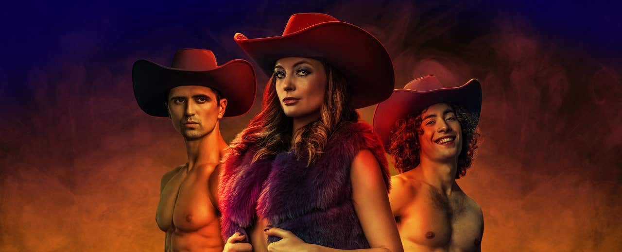 Three individuals wearing cowboy hats, two shirtless men and a woman in a fur vest, posed against a smoky background.