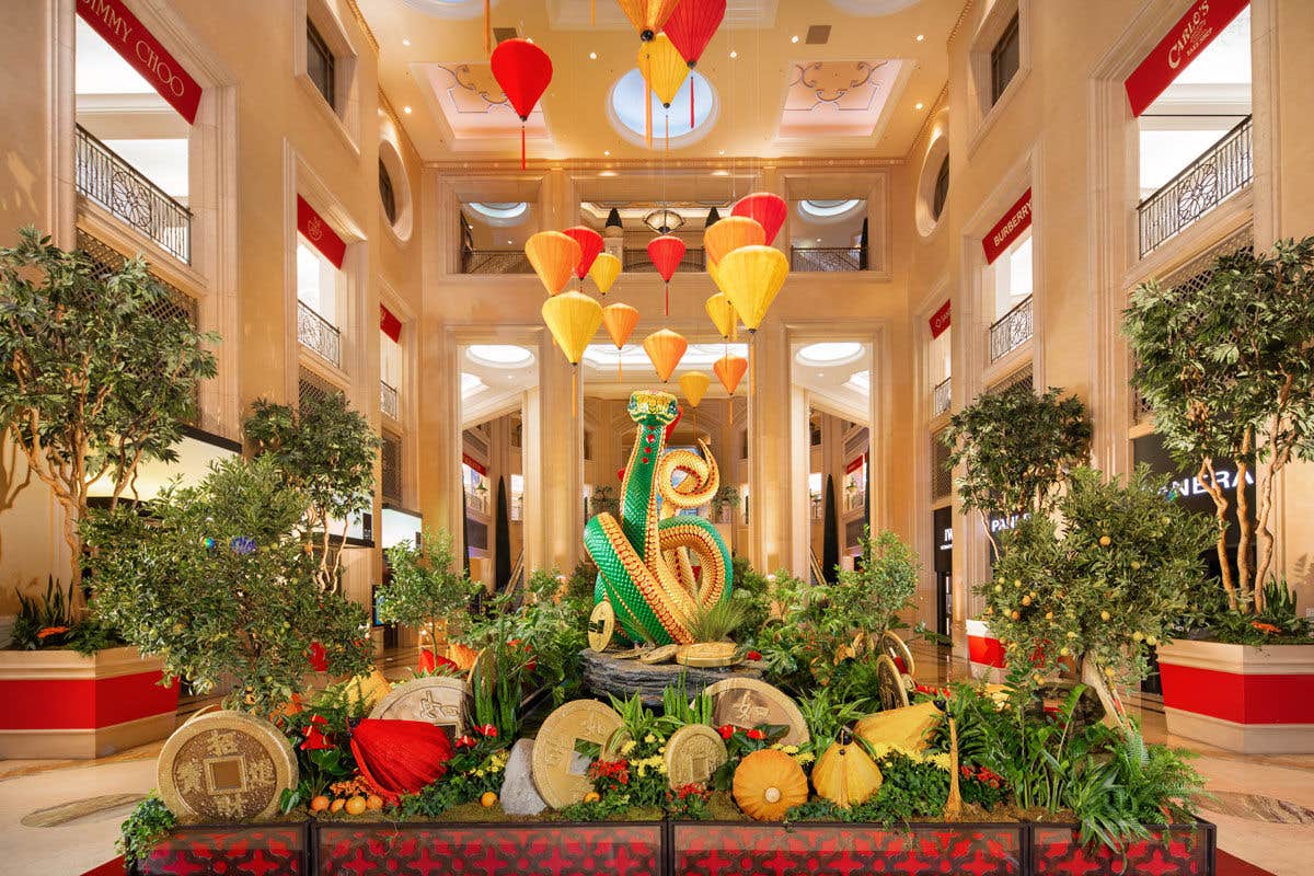 The atrium inside The Venetian Resort with a large snake statue, vibrant lanterns, and decorative foliage.