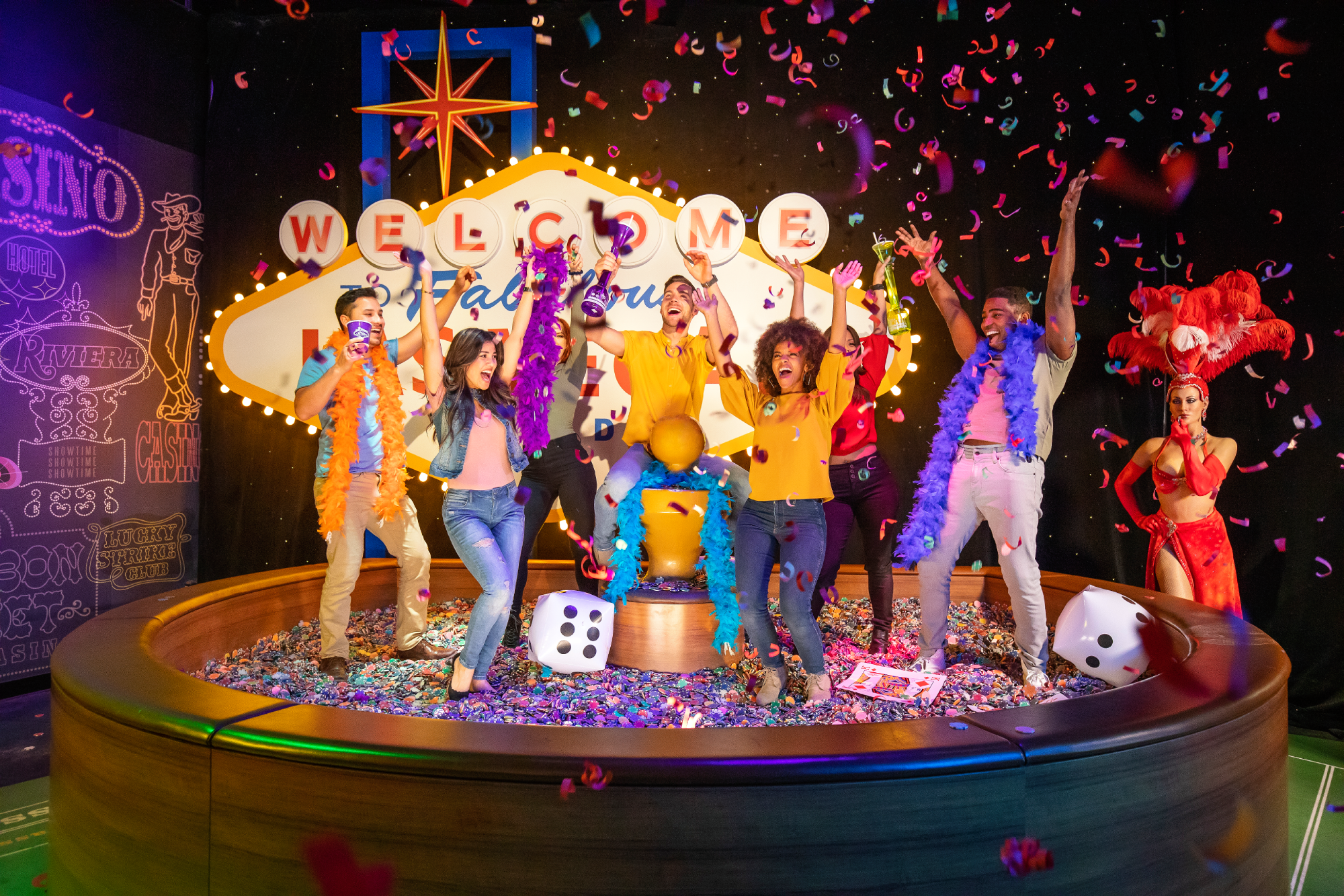 people celebrating in a pool of casino chips and dice