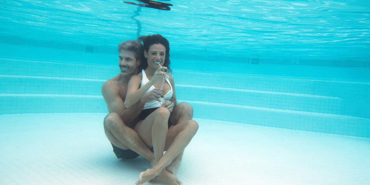 Couple holding each other at the bottom of a pool