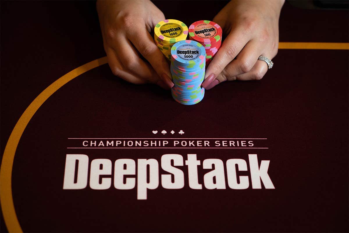 A pair of hand pushing three stacks of chips in on a DeepStack poker table