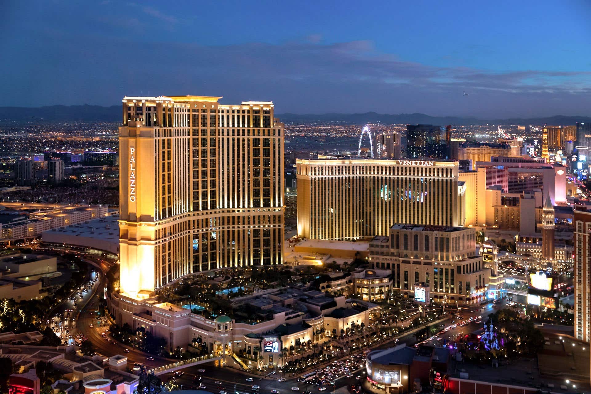 Aerial view of the Las Vegas hotels, The Palazzo and The Venetian resorts on the Las Vegas Strip, surrounded by city lights at dusk.