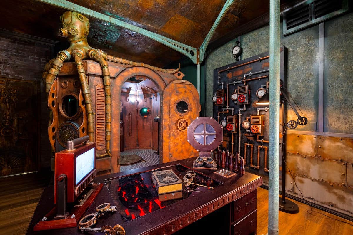 Steampunk-themed room with vintage machinery, submarine door, control panels, and decorative elements like gears and pipes. 