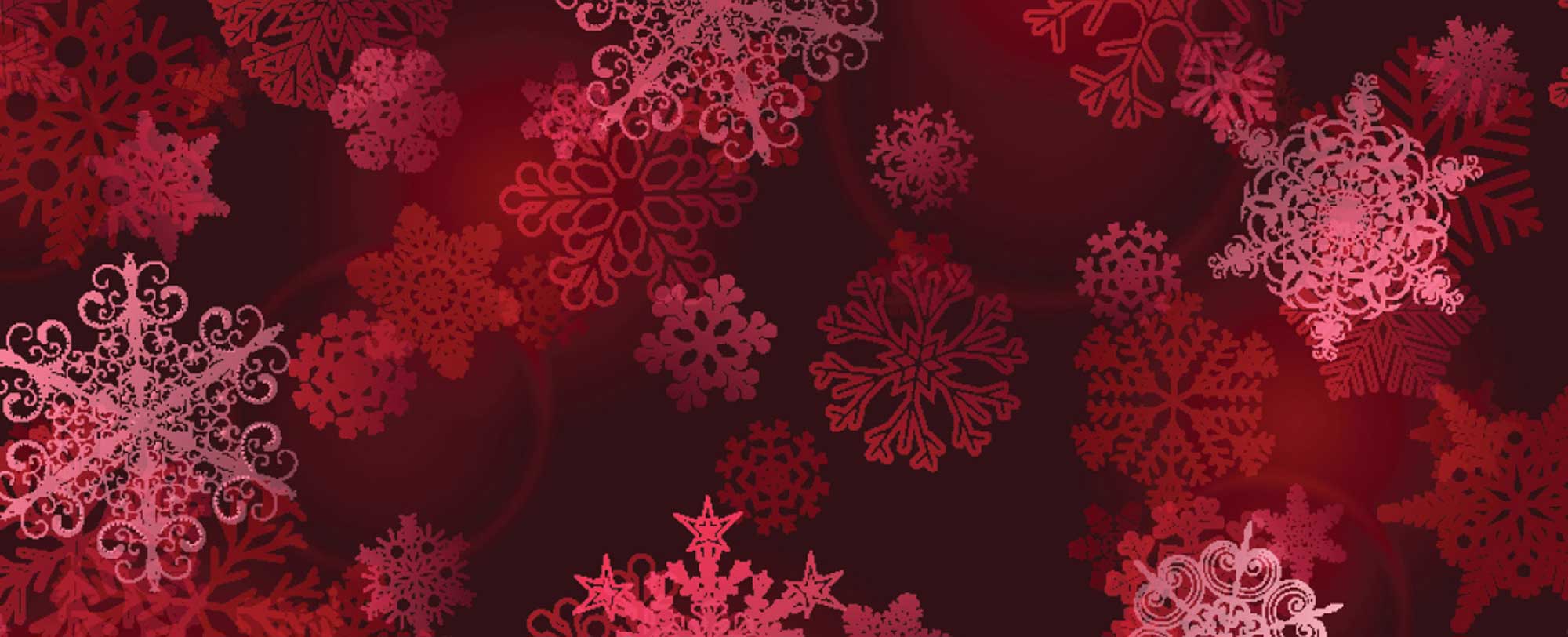 Red and pink snowflakes of various designs on a dark red background.