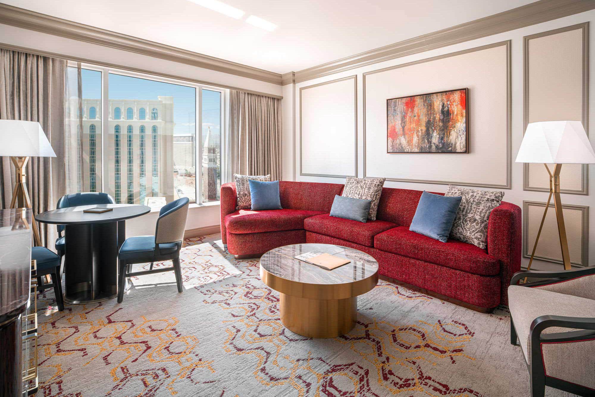 Modern living room with a red sofa, round coffee table, and large window.