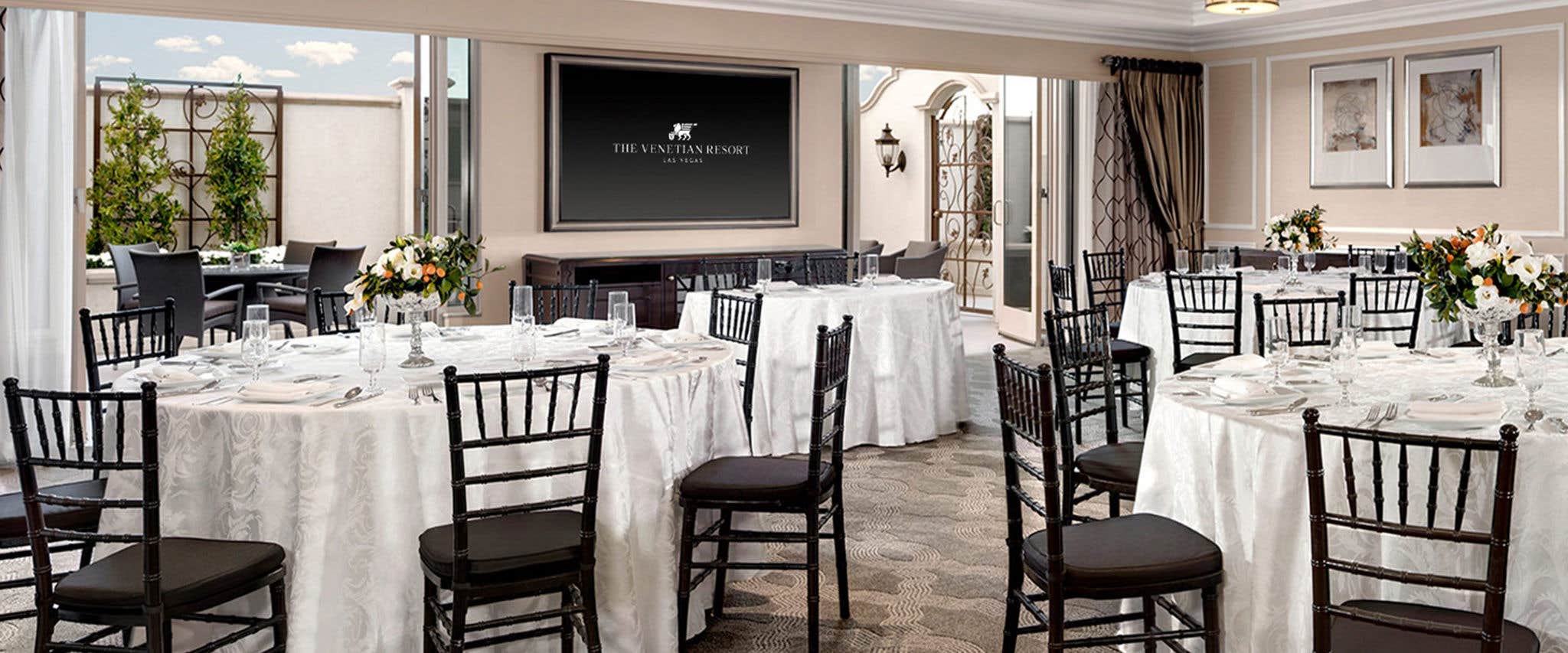 Interior of a Parlor at Venetian with round tables and white table coverings and light decor