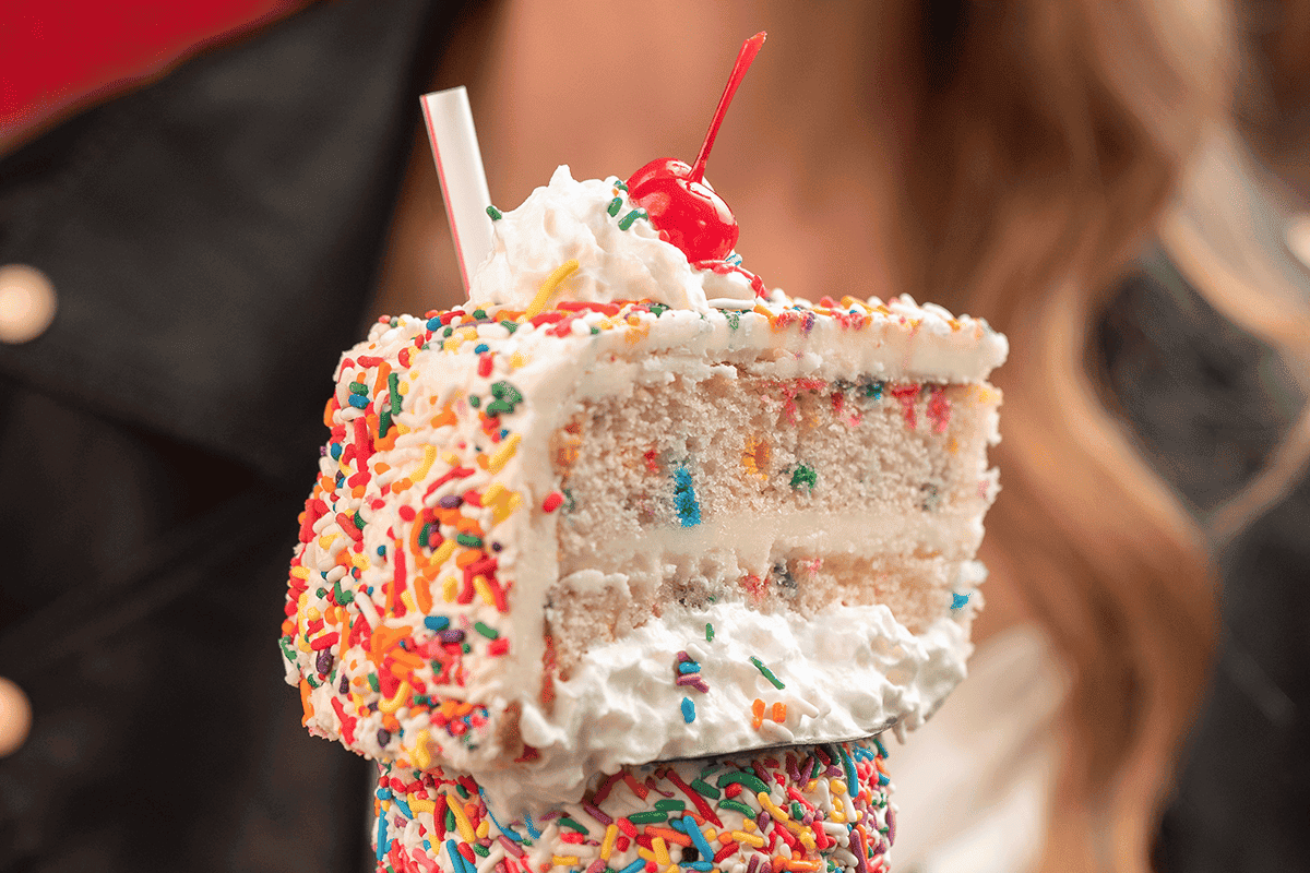 Milkshake with a piece of confetti cake on the top