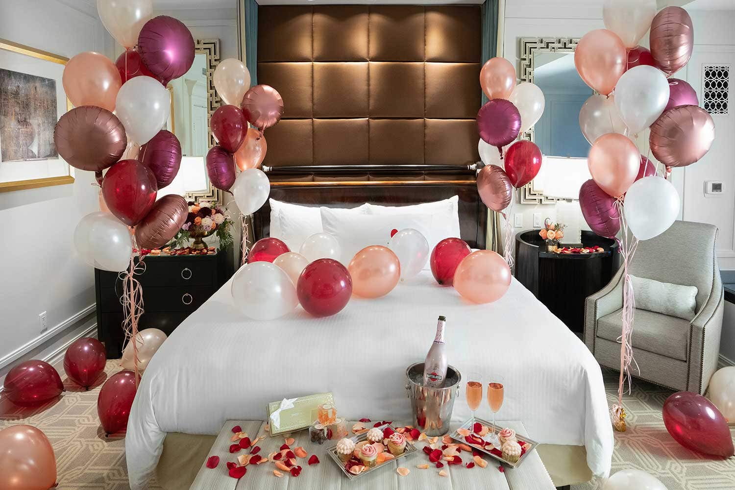 A white bed adorned with colorful balloons, creating a festive and cheerful atmosphere.