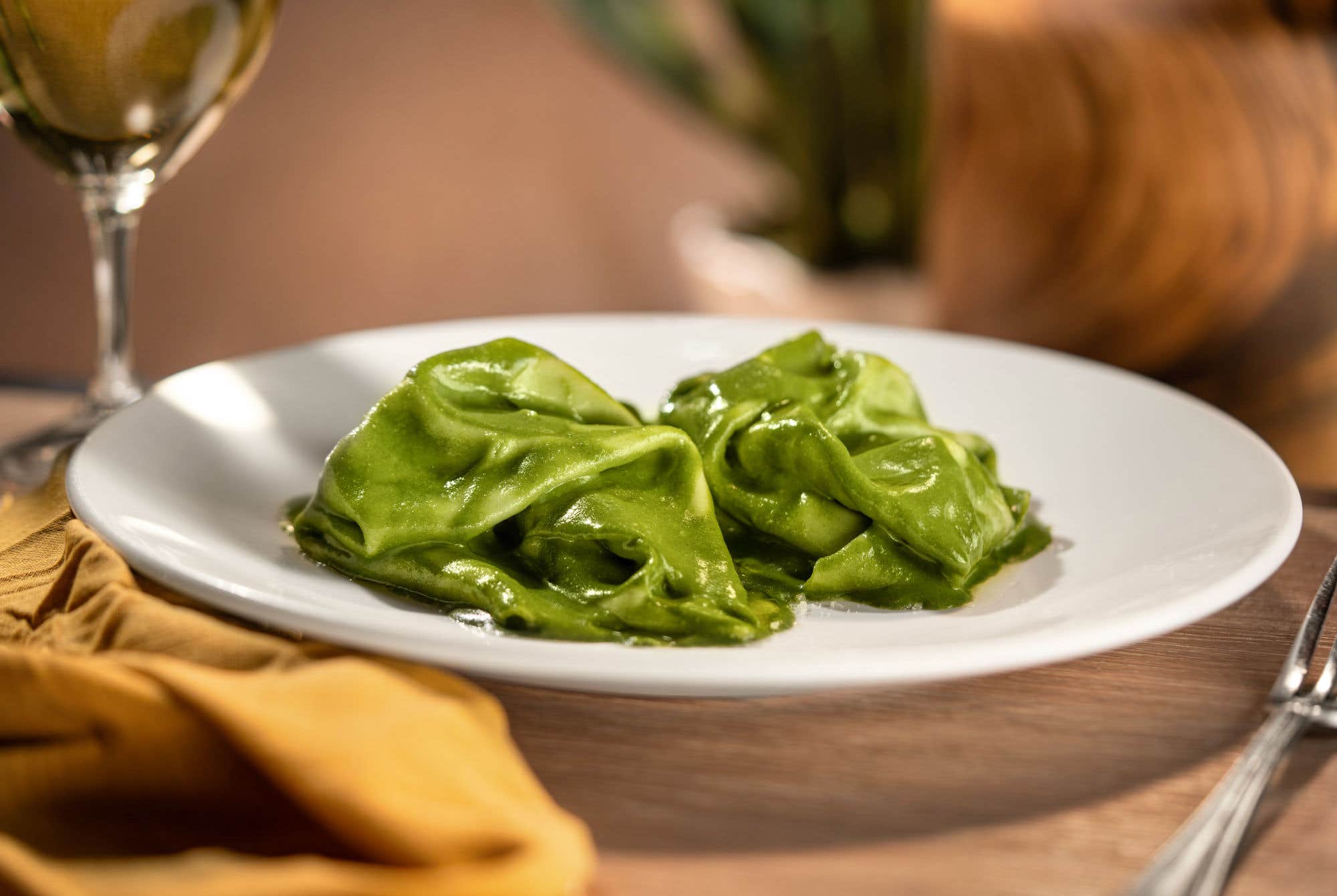 Vibrant green pasta with a glass of white wine