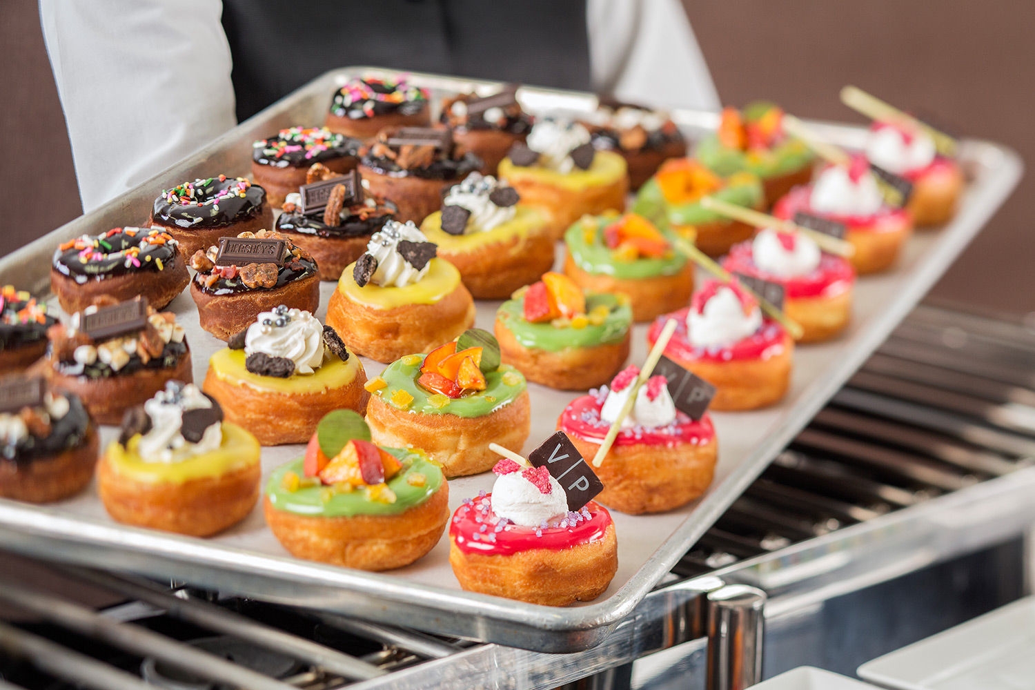 server holding tray of single bite dessert tarts