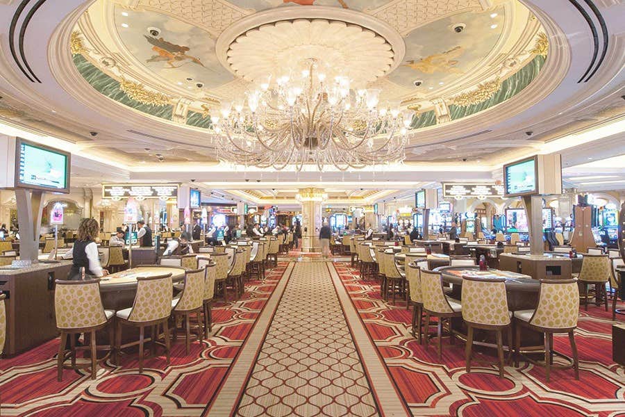 Interior of the casino featuring the table games area and a large chandelier.