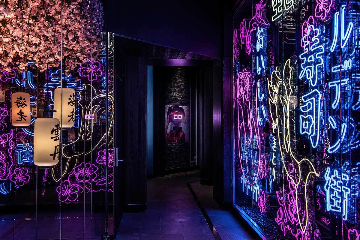 A dimly lit hallway adorned with vibrant neon signs and cherry blossom decorations on the ceiling.