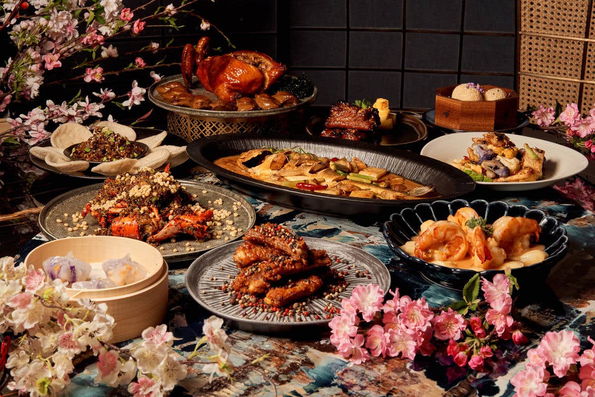 An array of Asian dishes displayed on a colorful table with cherry blossom decorations.