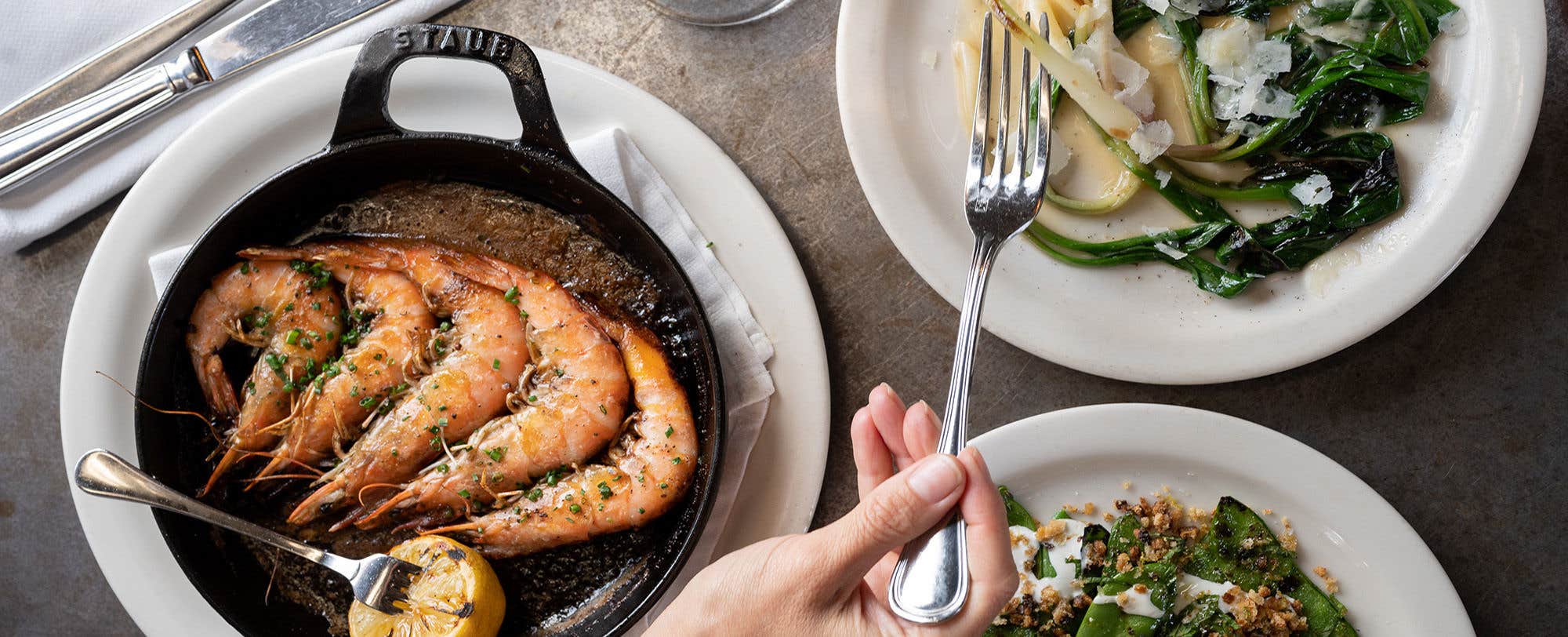 Prawns in a cast iron pan and a side of salad.