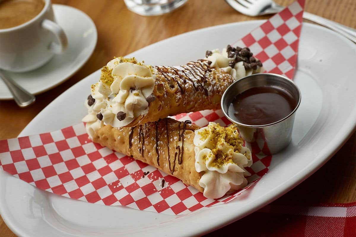 Two cannoli with chocolate drizzle