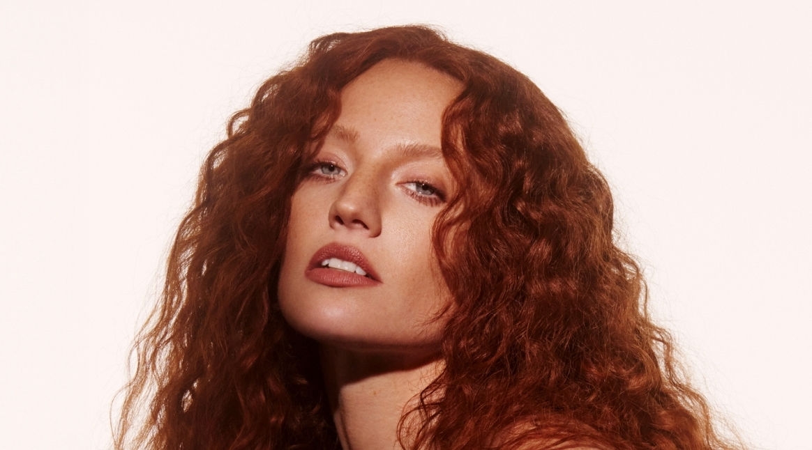 Jess Glynne posing in a leather jacket 