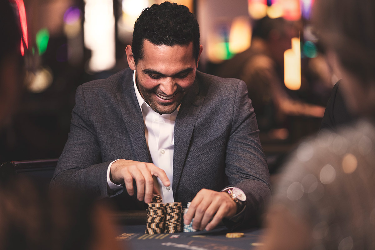 A man at a blackjack table counting his chips