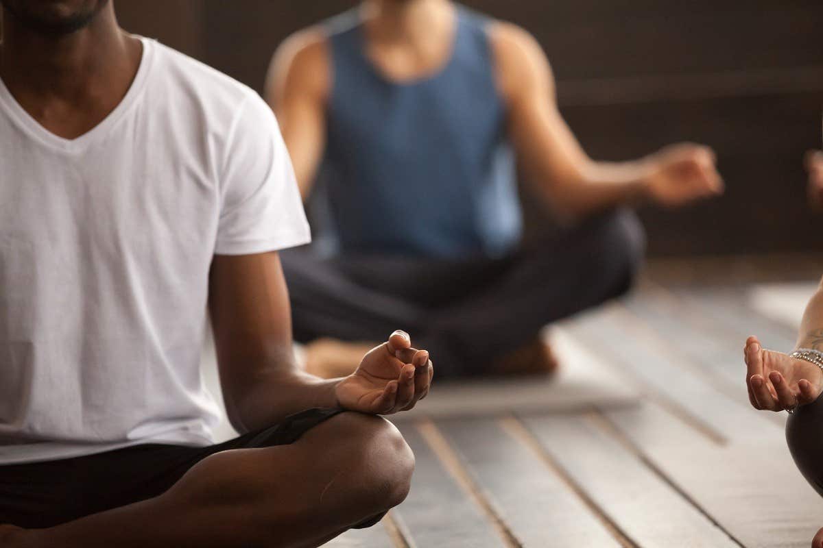 People sitting cross-legged on yoga mats in meditative poses during a group yoga session.