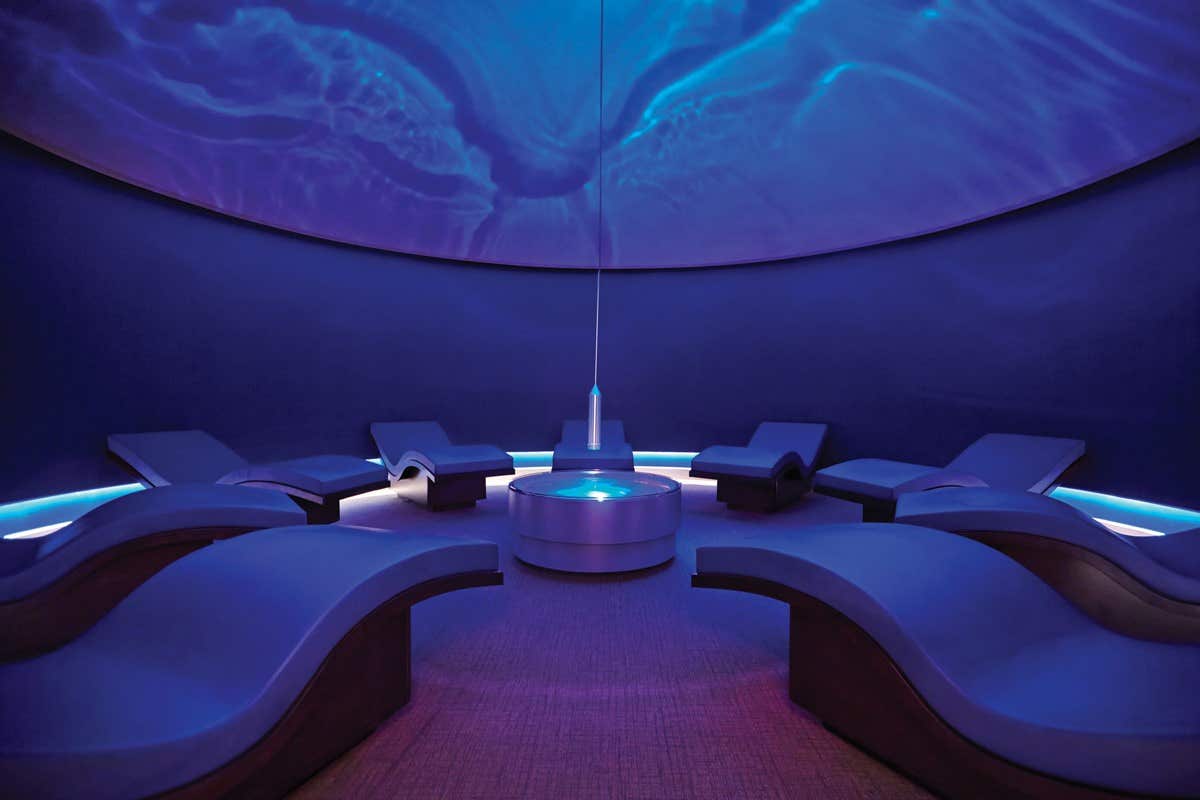 A serene lounge with curved chairs and ambient blue lighting creating a calming atmosphere.