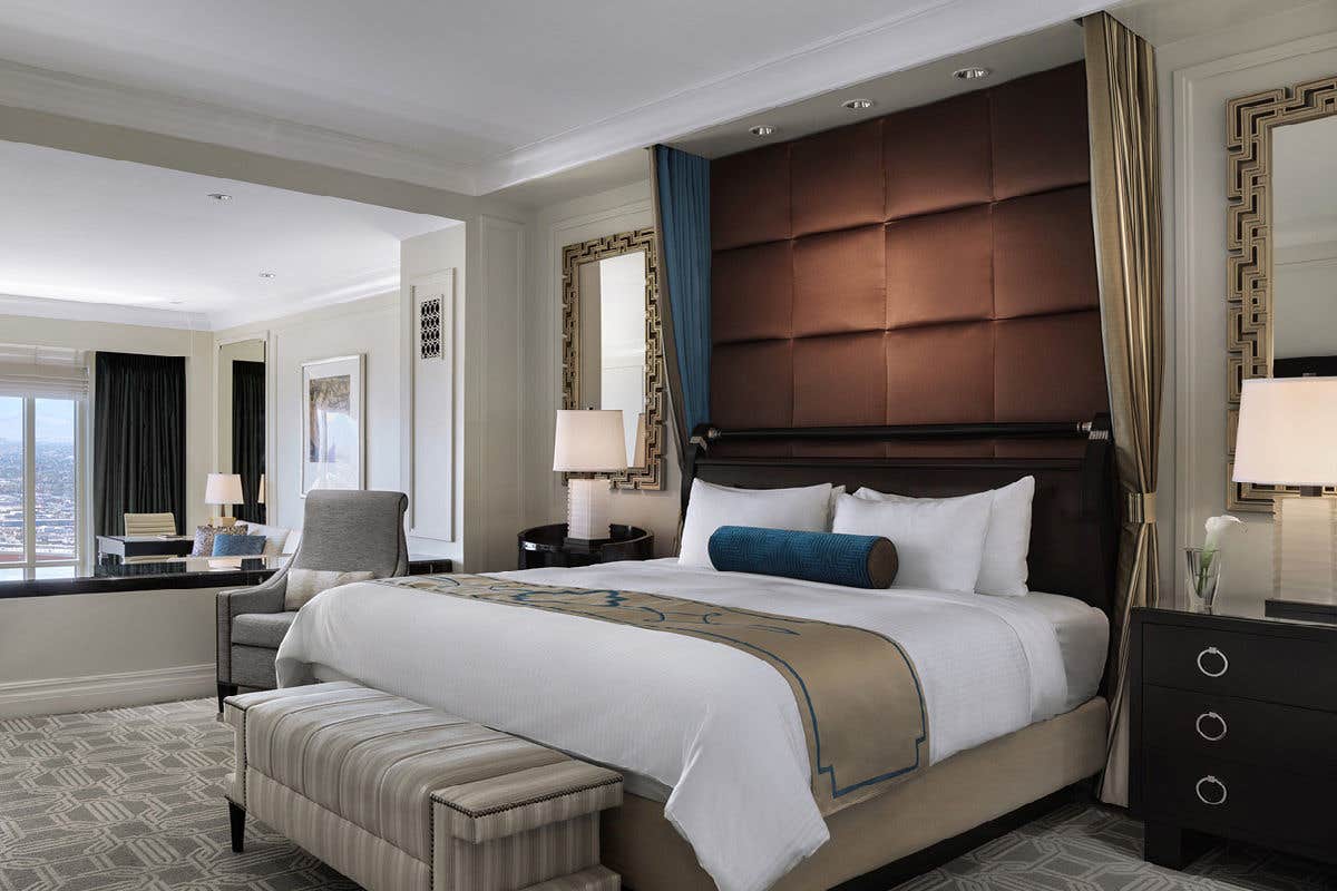 Luxurious hotel room with a king-sized bed, elegant decor, and sitting area.