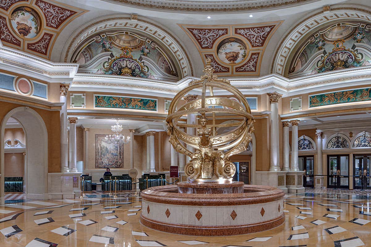 Opulent interior with a gold armillary sculpture and ornate architectural features.