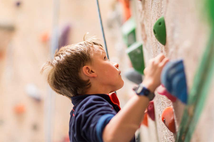 A child climbing on a rock climbing wall.