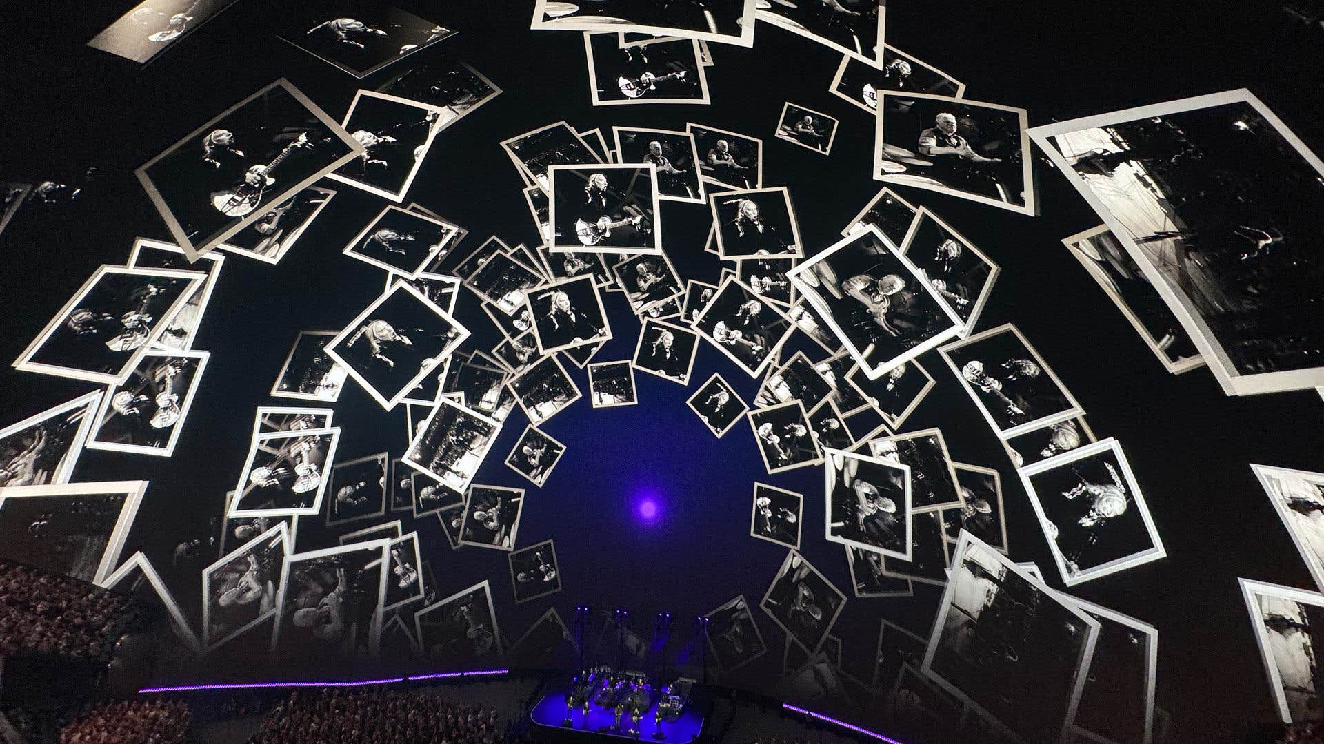 Numerous black-and-white photos of performances displayed in a dome with Eagles playing on stage below.