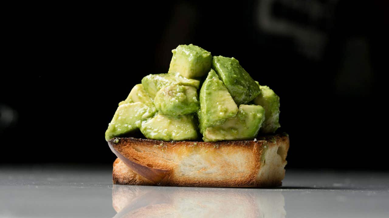 A slice of toasted bread topped with chunks of avocado.