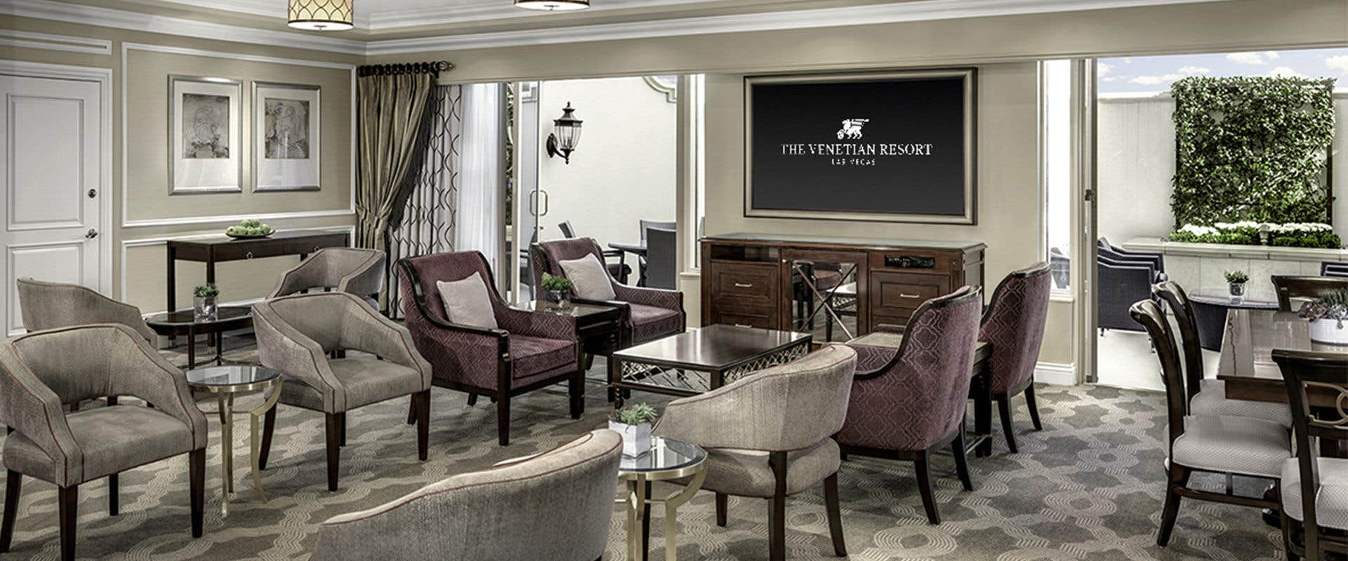 A room with chairs and table, and a TV on the wall. 