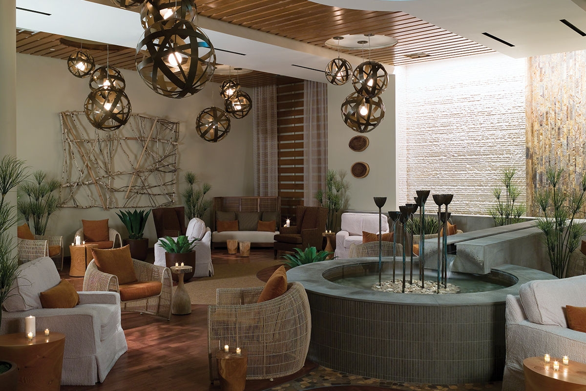 Luxury poolside cabanas with striped awnings, loungers, umbrellas, and pool in the foreground on a sunny day.